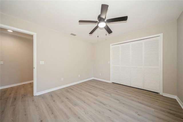 unfurnished bedroom with a closet, light hardwood / wood-style floors, and ceiling fan