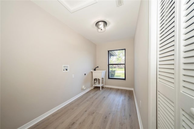 laundry room with hookup for an electric dryer, hookup for a washing machine, hookup for a gas dryer, and light hardwood / wood-style flooring