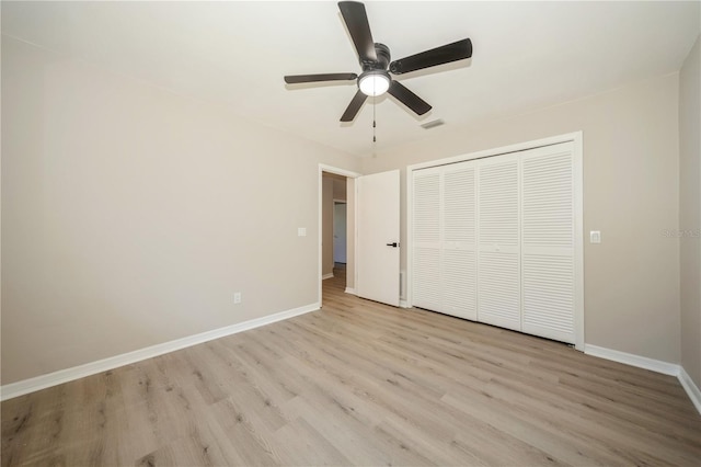 unfurnished bedroom featuring ceiling fan, light wood-type flooring, and a closet