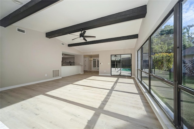 interior space featuring ceiling fan, sink, lofted ceiling with beams, and light wood-type flooring