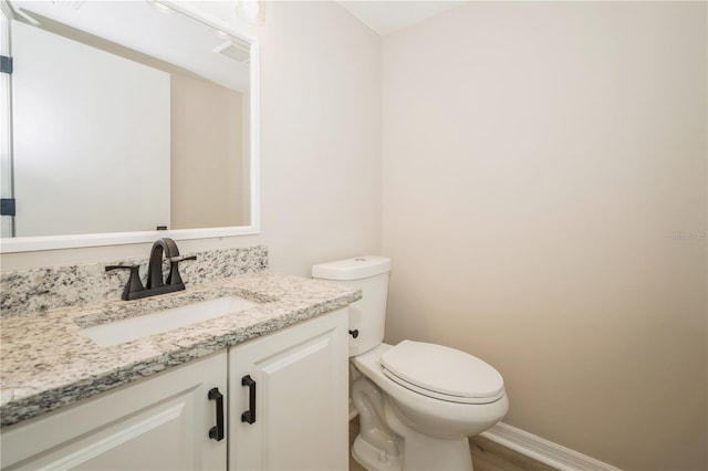 bathroom with vanity, wood-type flooring, and toilet