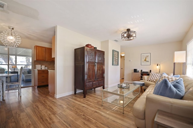 living room featuring a chandelier and light hardwood / wood-style flooring