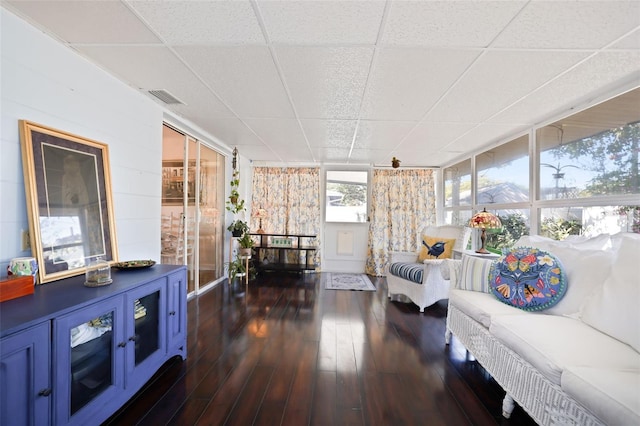 living room featuring expansive windows, a drop ceiling, and dark wood-type flooring