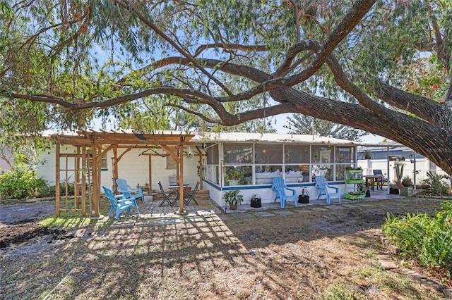 rear view of house with a patio area, a sunroom, and a pergola