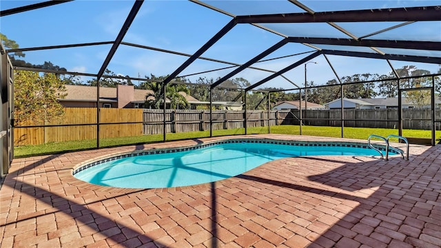 view of pool with a yard, glass enclosure, and a patio area