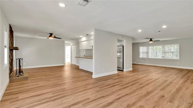 unfurnished living room featuring light hardwood / wood-style flooring and ceiling fan