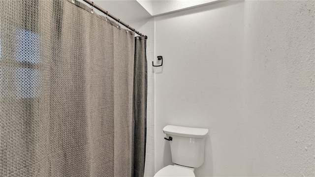 bathroom with curtained shower and toilet