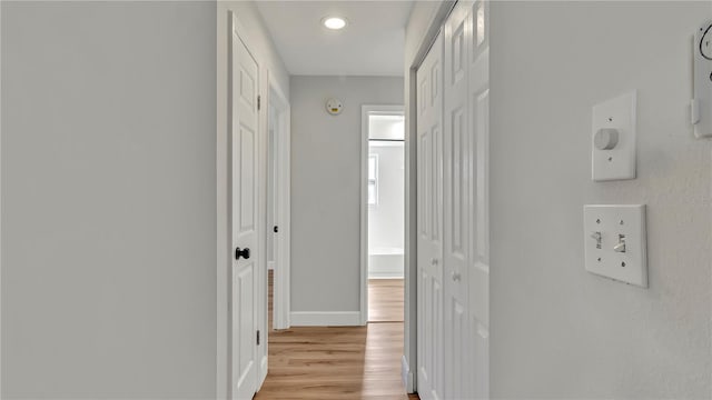 corridor with light hardwood / wood-style flooring