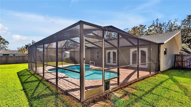 view of swimming pool featuring french doors, glass enclosure, a patio area, and a lawn