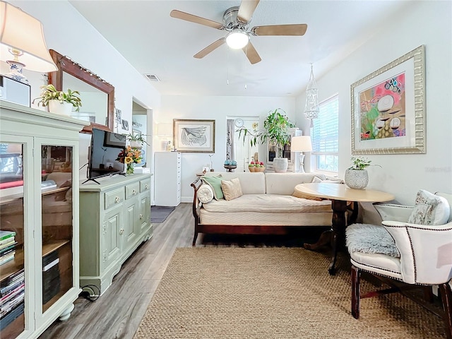 sitting room with wood-type flooring and ceiling fan