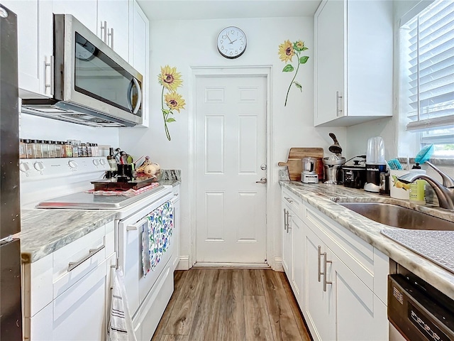 kitchen with white cabinetry, plenty of natural light, stainless steel appliances, and light wood-type flooring