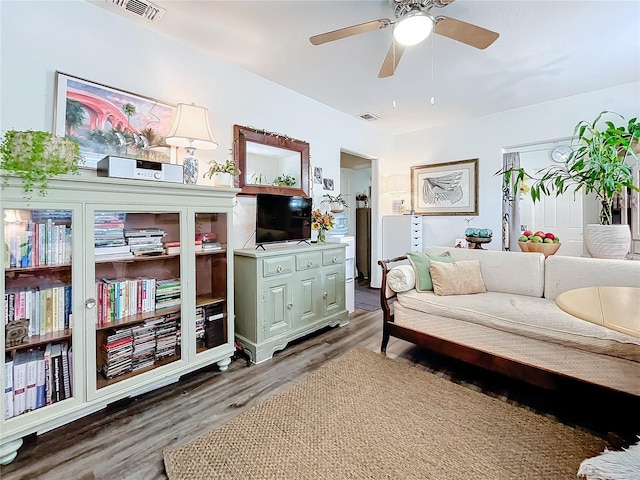 living area featuring ceiling fan and dark hardwood / wood-style floors