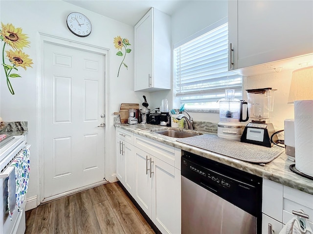 kitchen with white cabinetry, sink, light stone counters, stainless steel dishwasher, and light hardwood / wood-style floors