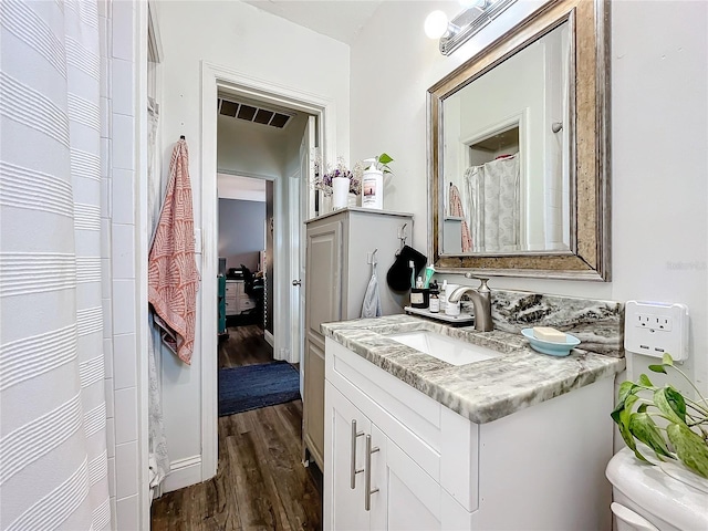 bathroom with vanity, toilet, and wood-type flooring