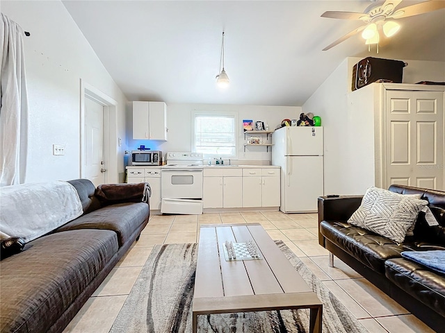 tiled living room featuring ceiling fan, sink, and vaulted ceiling