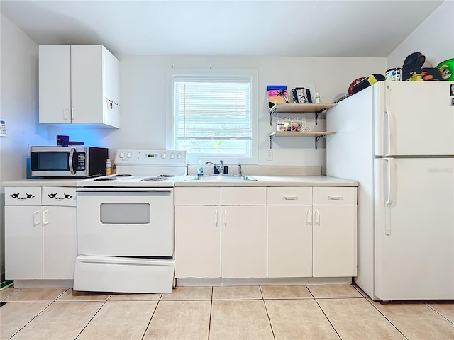 kitchen featuring white cabinetry, sink, light tile patterned floors, and white appliances