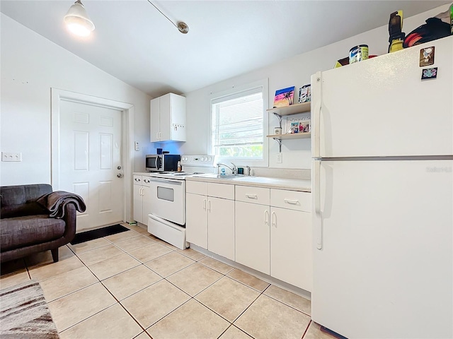 kitchen featuring sink, white cabinets, lofted ceiling, white appliances, and light tile patterned floors