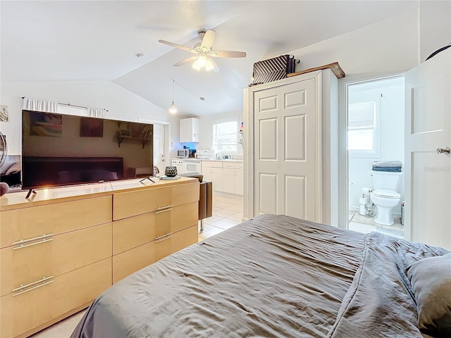 bedroom featuring vaulted ceiling, connected bathroom, light tile patterned flooring, and multiple windows