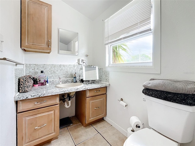 bathroom with tasteful backsplash, tile patterned floors, vanity, toilet, and lofted ceiling