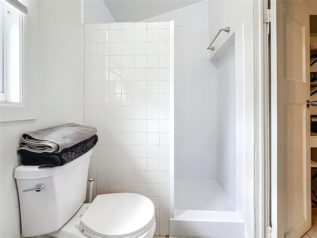 bathroom with walk in shower, vaulted ceiling, toilet, and tile walls