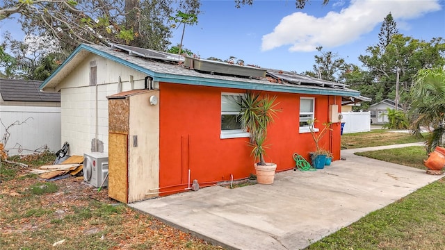 back of property featuring a patio area, ac unit, and solar panels