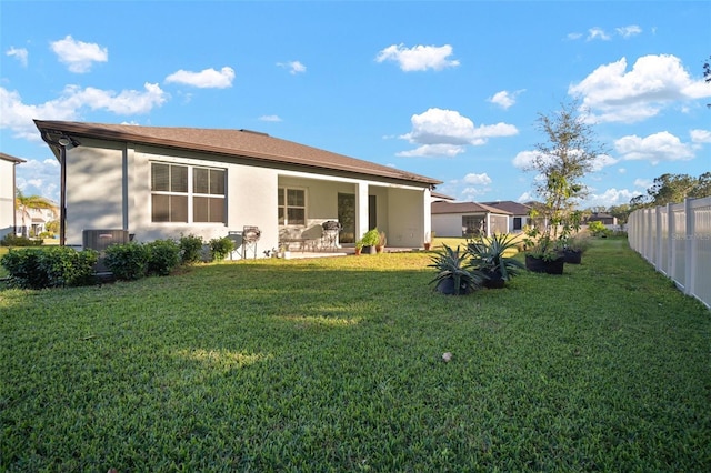 rear view of house featuring a yard and a patio area