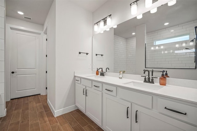 bathroom with tiled shower and vanity