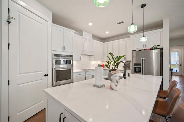 kitchen with white cabinetry, a center island with sink, and appliances with stainless steel finishes