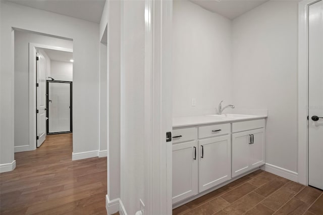 bathroom with hardwood / wood-style floors, vanity, and a shower with shower door