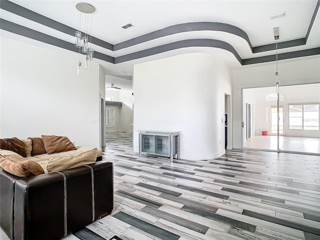 living room with wood-type flooring and a tray ceiling