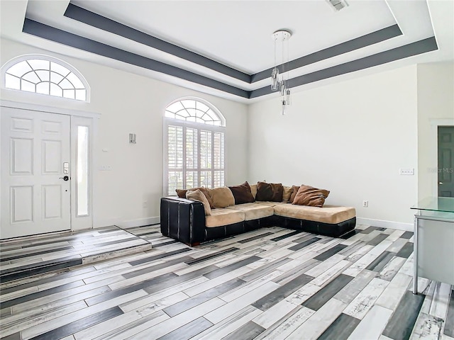 living room with a raised ceiling and light hardwood / wood-style flooring