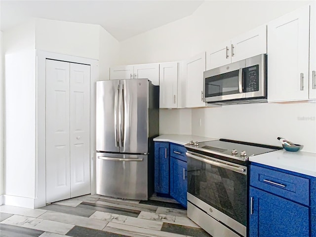 kitchen with light hardwood / wood-style flooring, blue cabinetry, white cabinets, and appliances with stainless steel finishes