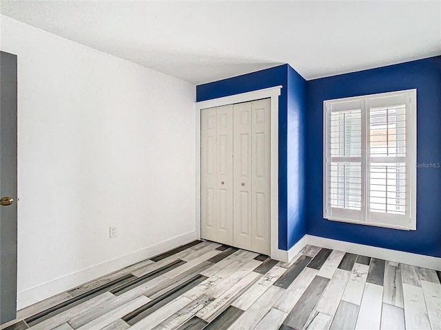 unfurnished bedroom with light hardwood / wood-style floors and a closet