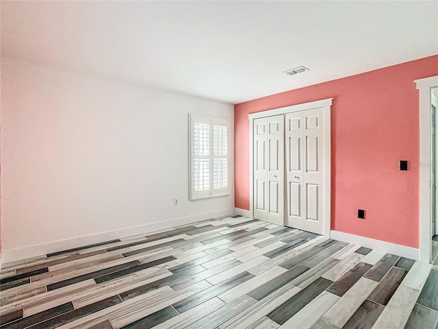 unfurnished bedroom with light hardwood / wood-style floors and a closet