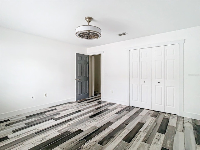 unfurnished bedroom featuring light hardwood / wood-style floors and a closet