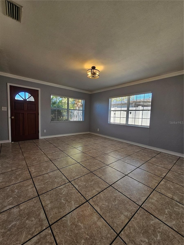 foyer with a textured ceiling and crown molding