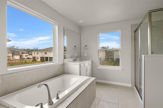 bathroom featuring plus walk in shower, tile patterned floors, and vanity