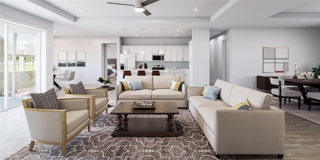 living room with ceiling fan, a tray ceiling, and wood-type flooring