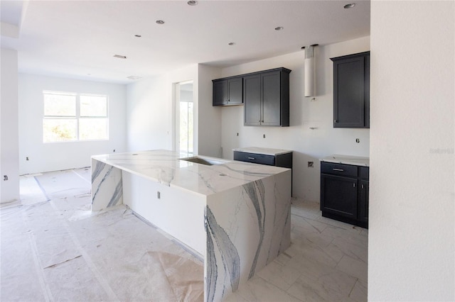 kitchen with light stone counters and a center island