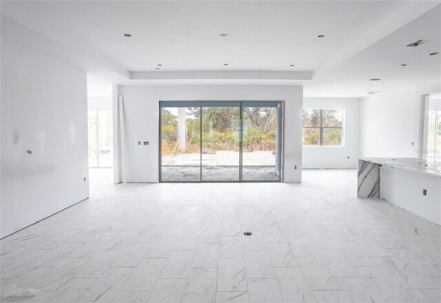 unfurnished living room with a raised ceiling