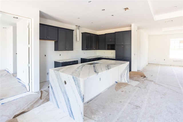 kitchen featuring light stone counters and a large island