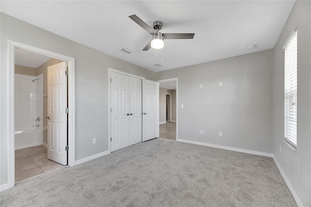 unfurnished bedroom featuring ceiling fan, light colored carpet, and ensuite bathroom