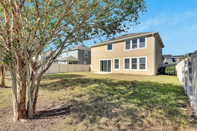 rear view of property featuring a yard