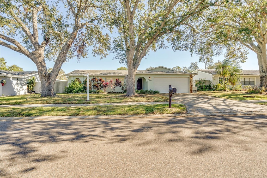 single story home featuring a garage and a front yard