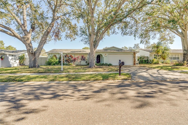 single story home featuring a garage and a front yard