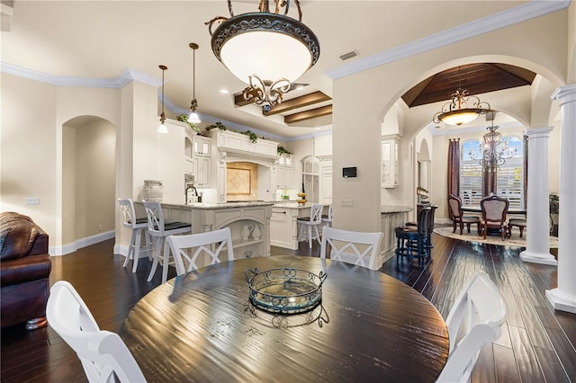 dining area with a notable chandelier, dark hardwood / wood-style flooring, ornamental molding, beam ceiling, and sink