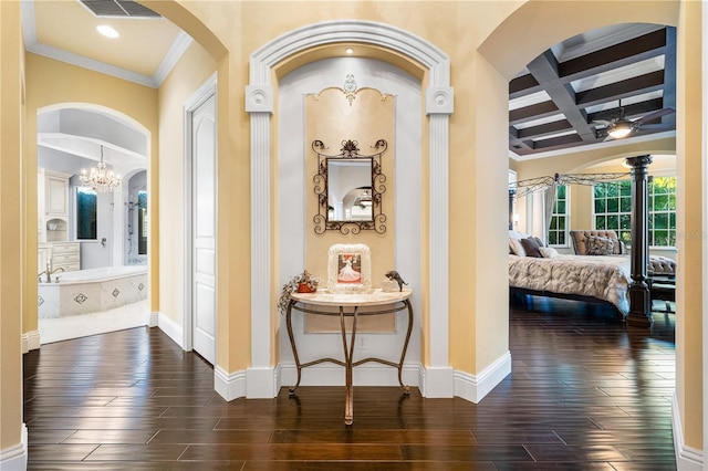 corridor featuring a notable chandelier, beamed ceiling, coffered ceiling, and ornamental molding