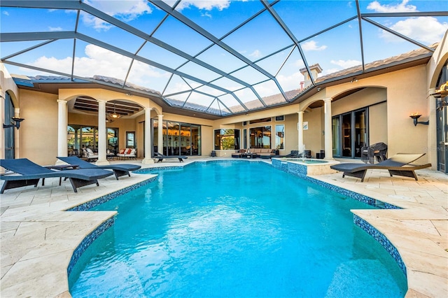 view of pool with glass enclosure, a patio area, and an in ground hot tub