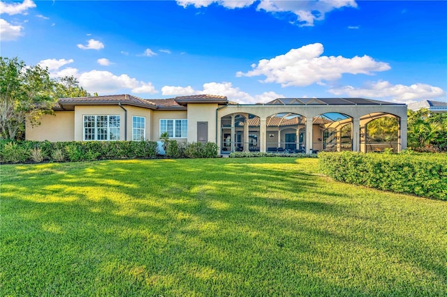 back of property featuring glass enclosure and a yard