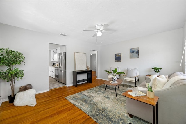 living room with hardwood / wood-style floors and ceiling fan